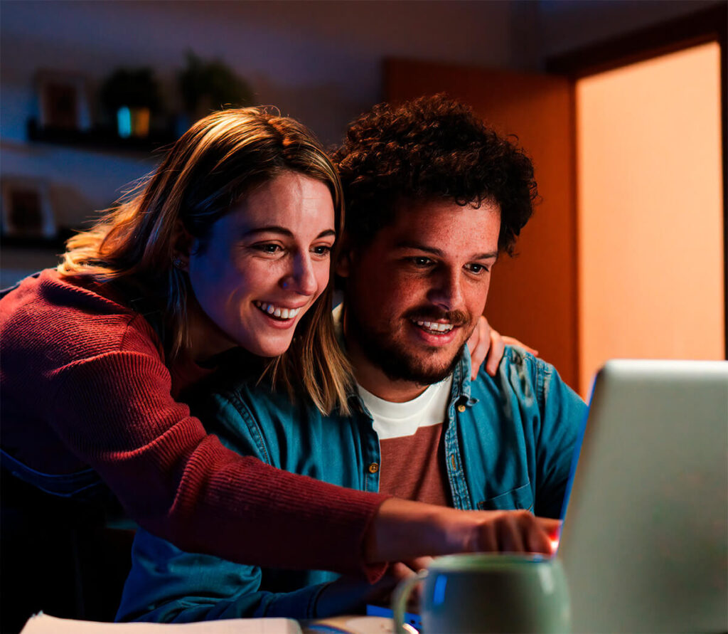 Pareja sonriendo frente a su nueva web